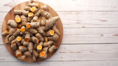 top view of turmeric root on a chopping board on table .