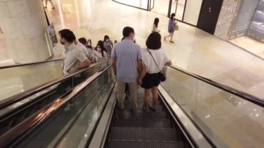 Singapur 12 Haziran 2022, Plaza Singapur 'da yürüyen merdivende alışveriş yapanlar.