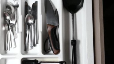 cutlery fork and knife in a drawer top view .