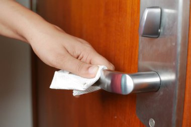 Kağıt mendille kapı kolunu temizliyorum. ,
