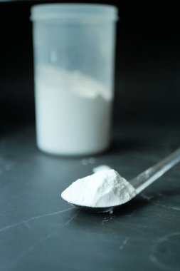 Siyah arka planda plastik kaşıkta yıkama tozu ,