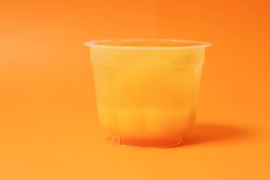 orange jelly in a plastic container .