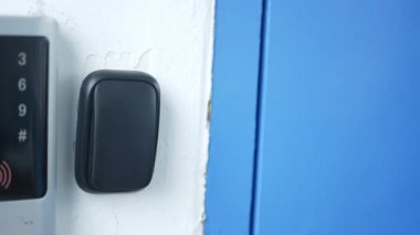 A woman presses a black doorbell .