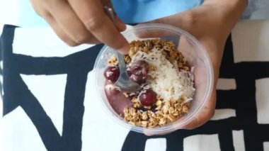 women holding a bowl of breakfast cereal on table .
