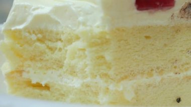 eating vanila cream cake on a plate on table ,