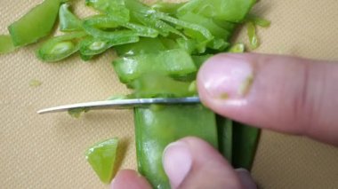 women cutting Holland beans on the cutting board.