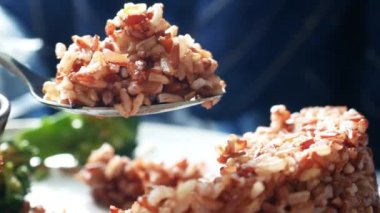 cooked red rice on spoon, haradighi rice ,