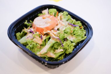 fresh vegetable salad in a take away packet on table ,