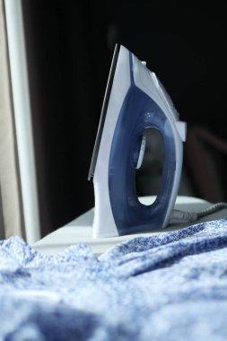 iron and cloths on ironing board