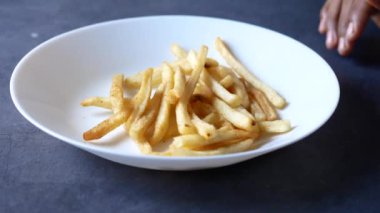  Siyah arka plandaki tabaktan patates kızartması seçiyorum. ,