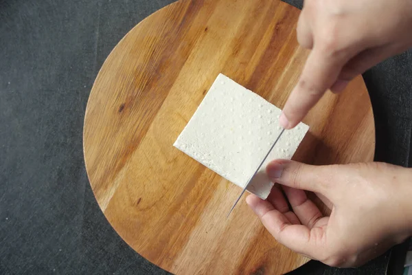 Bovenaanzicht Van Handen Snijden Tofu Met Mes — Stockfoto