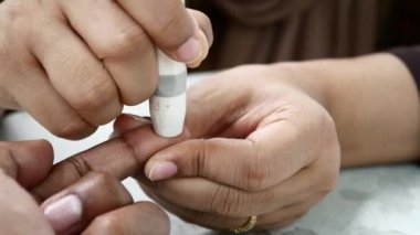 Delikanlılar evlerinde glikoz seviyesini elle ölçerler..