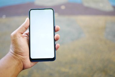 Açık havada akıllı telefon kullanan genç bir adamın dikiz görüntüsü .