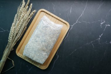 top view of oats flakes in a plastic packet on table .