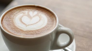 Kafenin tepesinde çiçek desenli geç kalmış bir fincan kahve. .