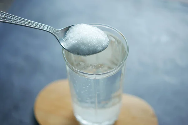 Masadaki Bir Bardak Suya Beyaz Şeker Dök — Stok fotoğraf