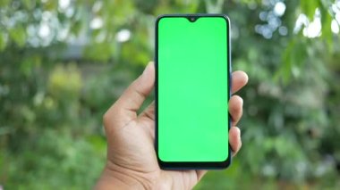 Açık havada akıllı telefon kullanan genç bir adamın dikiz görüntüsü .