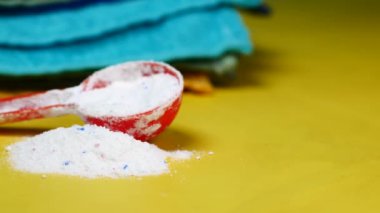 Mavi arka planda plastik kaşıkla yıkama tozu ,