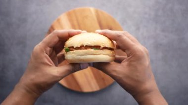 Masanın üstünde el ele tutuşan sığır burger. ,