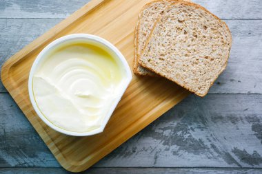 Beyaz zemin üzerinde ekmek olan bir kabın içinde taze tereyağı .