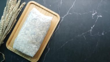 top view of oats flakes in a plastic packet on table .