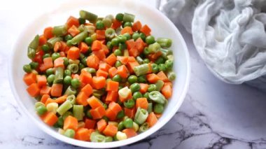 Mısır, havuç ve fasulyeyi kaseye koy.