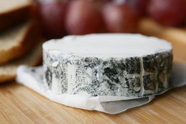 木制背景的新鲜山羊奶酪和葡萄果 — 图库照片