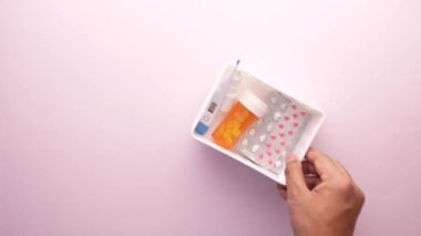 Plastik bir düzenleyicide tıbbi hap kutusu, su toplayıcısı ve termometre. .