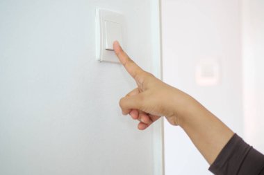 Işık düğmesini açan bir parmak