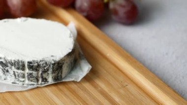 Tahta zeminde taze keçi peyniri ve üzüm meyvesi...