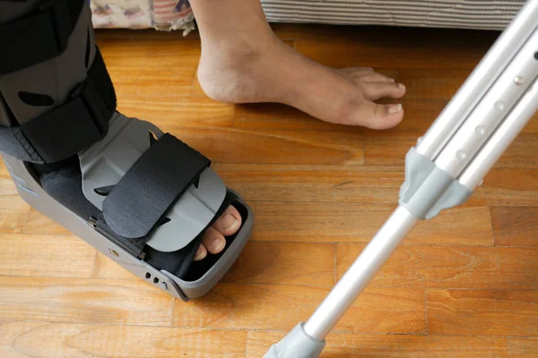 グレーのプラスチック製のブーツの足首ブレースの怪我で足を骨折 — ストック写真