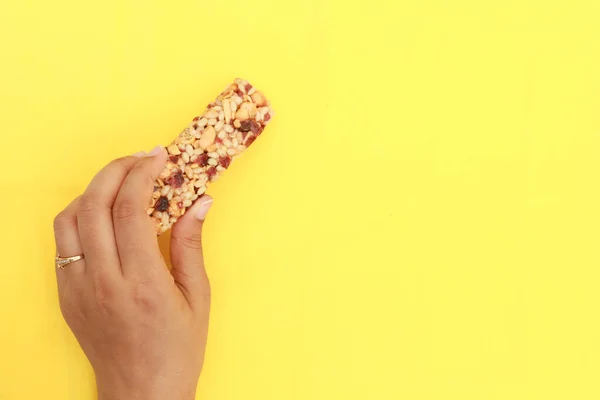 women holding a protein bar on yellow background ,