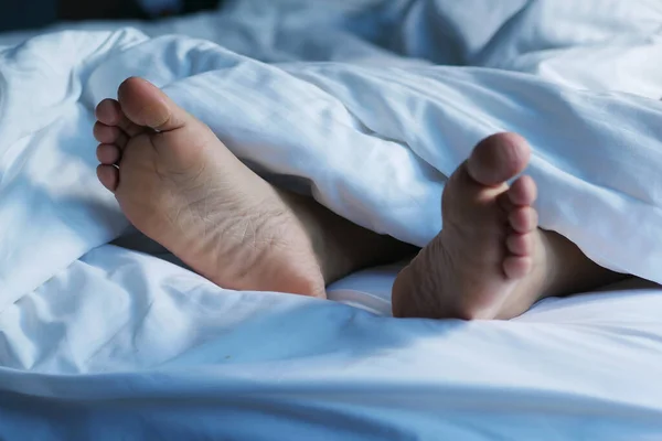 Beyaz yatakta kadın ayakları ,
