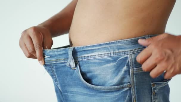 男性はジーンズをはいて体重減少を示し — ストック動画