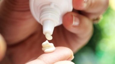 Açık havada güneş kremi kullanarak kişinin elini kapat. ,