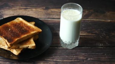 Masada bir bardak süt ve kızarmış ekmek. ,