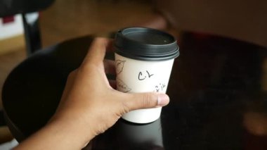 Kâğıt kahve bardağını kahve masasının üstüne koy. ,