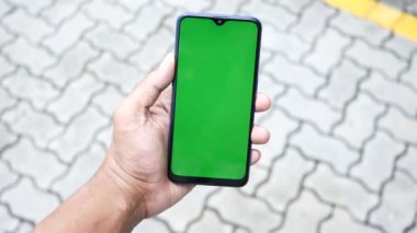 Sokakta akıllı telefon taşıyan bir gencin pov fotoğrafı. ,