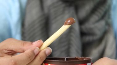 Çikolata soslu ekmek çubuğu yemek. ,