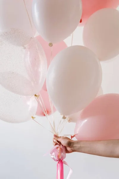 Doğum günün kutlu olsun. Bir insanın elinde tuttuğu pembe balonlar.