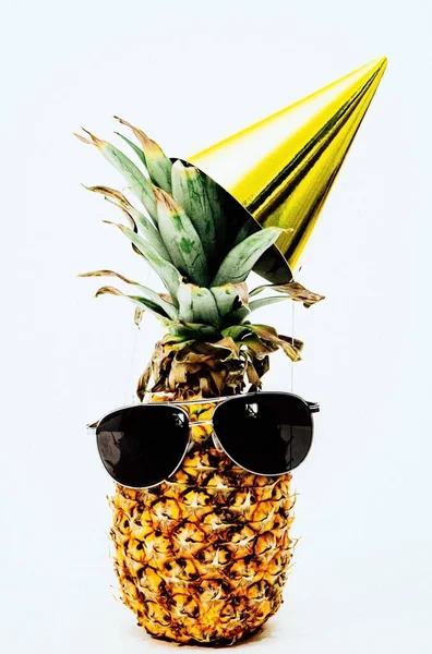 Happy Birthday close up photo of pineapple with party hat and a black sungla
