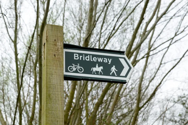 A wooden public bridleway sign post