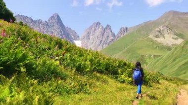 Arkaya bakan kadın yürüyüşçü Georgia 'daki Kazbegi Ulusal Parkı' nda yürüyüş yapıyor. Juta 'dan Roshka yürüyüş rotasına