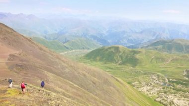 Chaukhi Massif KAzbegi Ulusal Parkı 'nda 3340 metre irtifa panoramik görüntüsünü geçti. Yürüyüşçüler Kazbegi 'de manzaranın keyfini çıkarıyorlar..
