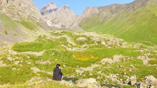 Vista Estática Mulher Pensativa Sentar Penhasco Rochoso Com Montanhas Panorâmicas — Vídeo de Stock