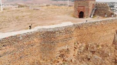 Kadın turist, Gori şehrinin panoramik manzarasıyla kalenin tepesinde selfie çekiyor. Kötü hava koşullarında seyahat macerası