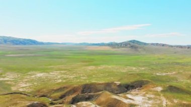 Havadan aşağıya doğru eğimli, Chachuna doğa koruma alanındaki çamur yanardağlarını, güneşli bir günde yeşil alan arkaplanını, Kakheti, Georgia