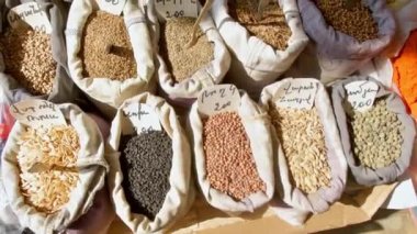 Doğal tohumlarla dolu çantalar ve tahıllar açık pazarda güneşte beyaz torbalarda, Ermenistan geleneksel pazarında