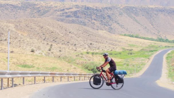 風光明媚な自然の中で屋外の極端な熱で赤い自転車の上り坂の上に静的なビュー白人男性サイクルソロ 自転車ツーリングアドベンチャーライフスタイルコンセプト — ストック動画