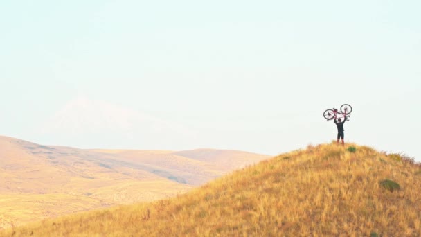 独立适合年轻的高加索男子骑自行车上山 高山背景在高加索山区 挑战和决心概念 — 图库视频影像